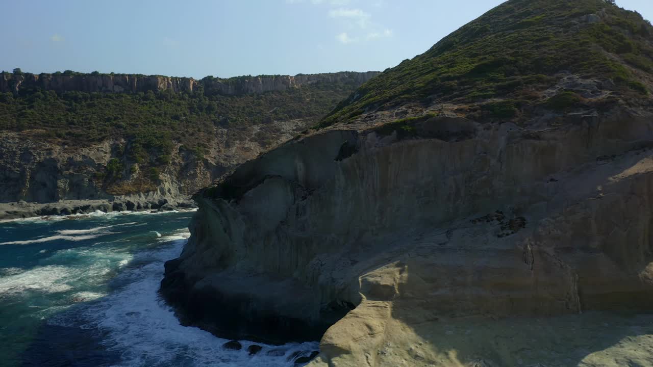 在意大利撒丁岛的博萨，无人机拍摄海浪撞击凯恩马鲁悬崖的画面视频素材