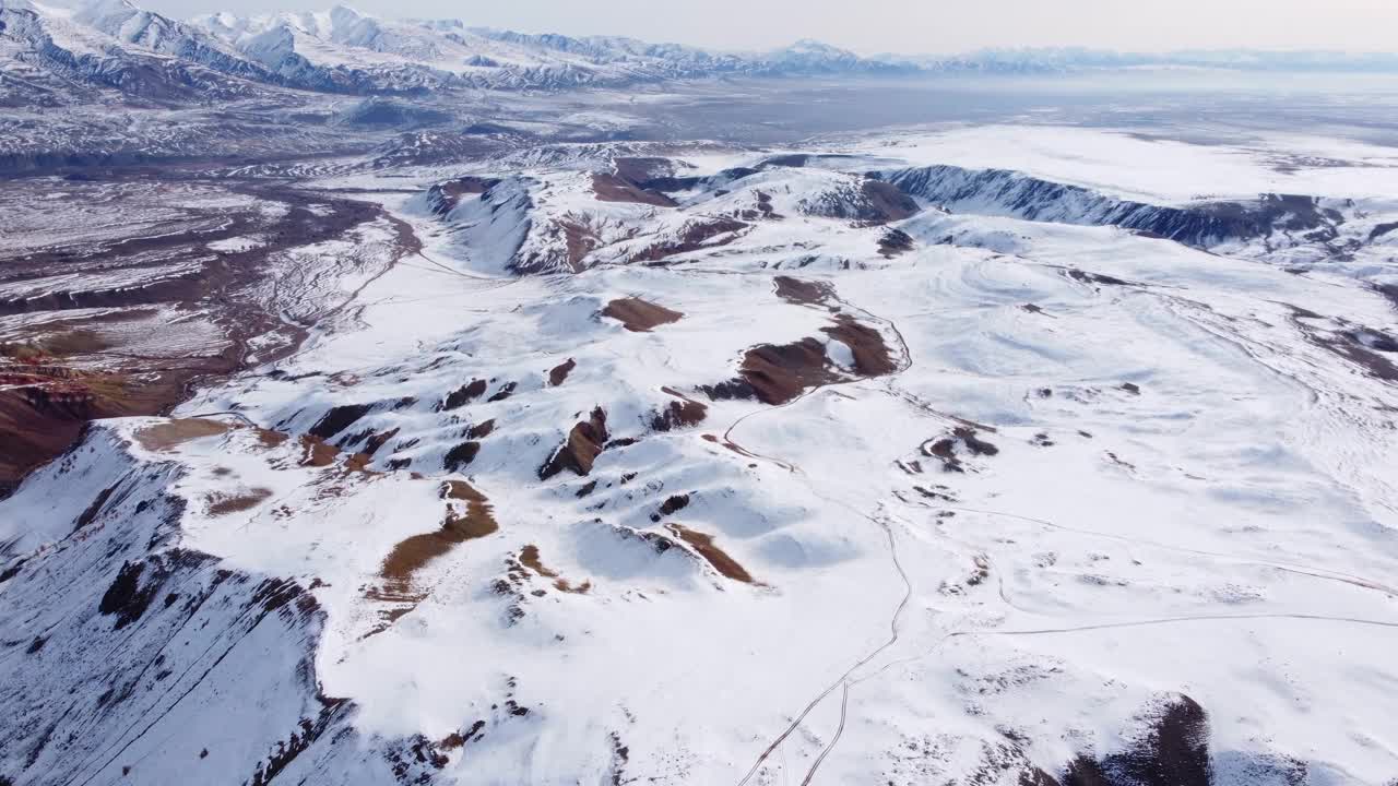 在多云的蓝天下，无人机拍摄的白雪皑皑的山顶视频素材