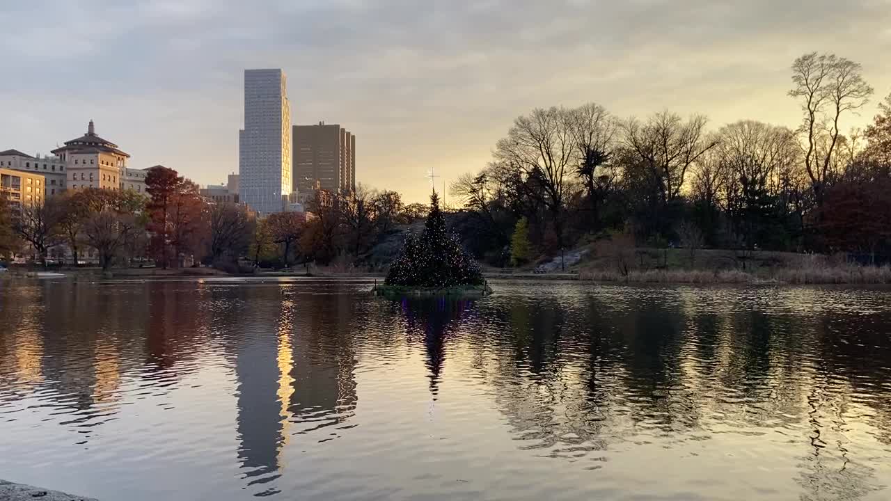 黄昏时分，纽约的天际线和树木映照在中央公园哈莱姆湖的水面上视频素材