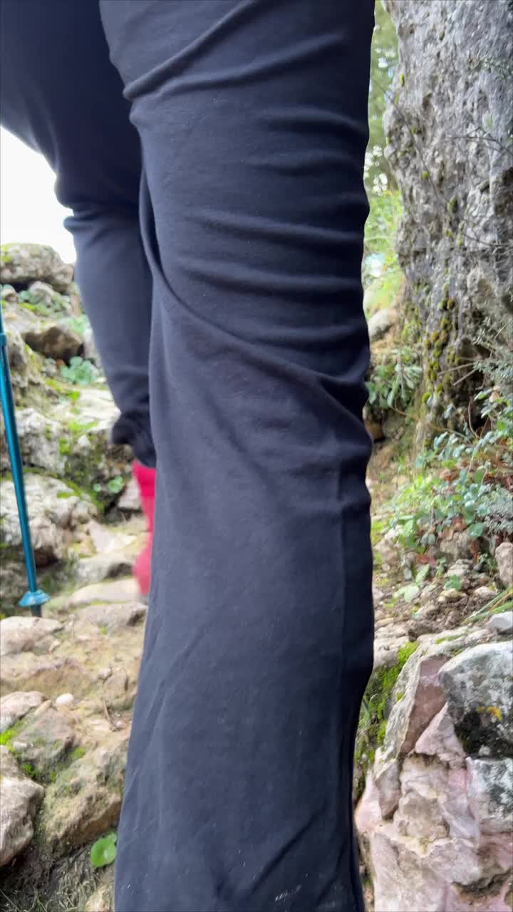 一个穿着红靴子的成年妇女带着她的狗在山里徒步旅行的特写后视图视频下载