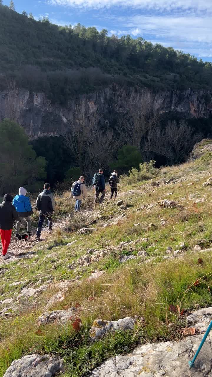 一群成年人带着十几岁的孩子在山里徒步旅行。视频下载