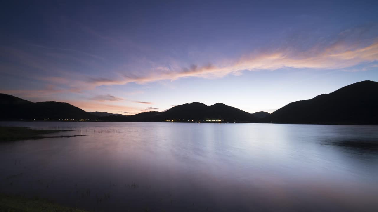 泰国南部，日出时五彩缤纷的天空反射在水面和山脉上视频下载