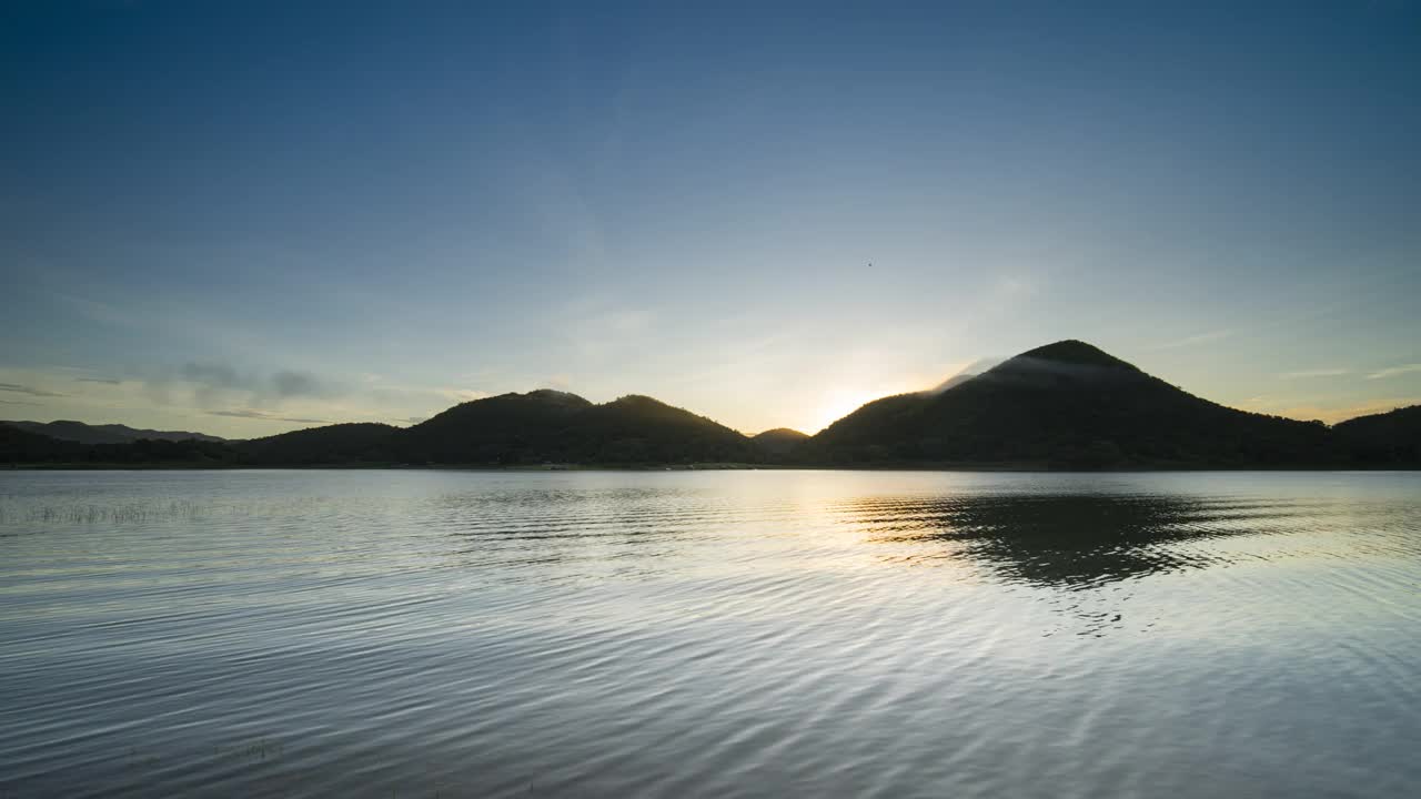 泰国南部，日出时五彩缤纷的天空反射在水面和山脉上视频素材