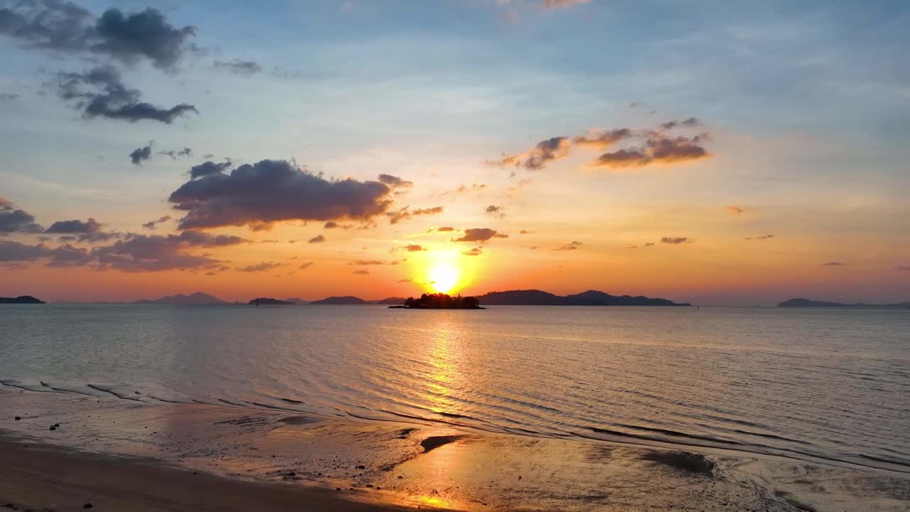 景观与日落的天空在海洋上，大海作为水的波浪在岛上作为黎明的天空场景视频素材