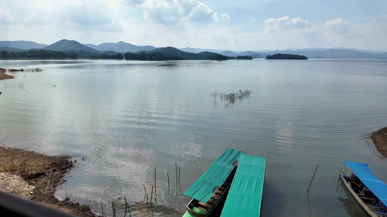 康克拉灿大坝的景观与船码头在湖岸，蓝天白云在晴朗的日子在山的背景。泰国噶叻山国家公园，清澈的海水伴着小波浪。视频素材