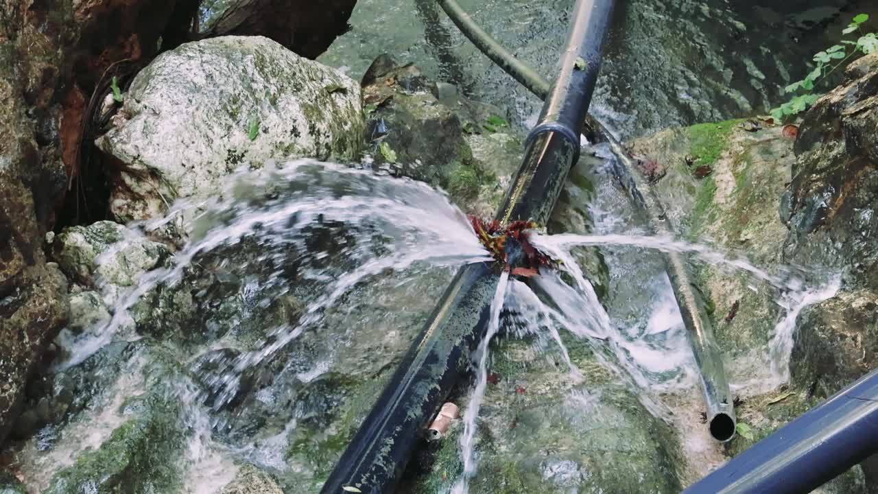 管道漏水对环境造成破坏，石头间漏水。特写环境破坏，彰显大自然的抗争。管道泄漏，环境破坏的一个鲜明例子视频素材