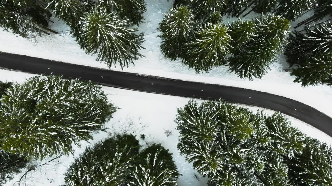 在一个下雪的冬日，一辆露营车在法国阿尔卑斯山的山口公路上的无人机剪辑视频素材