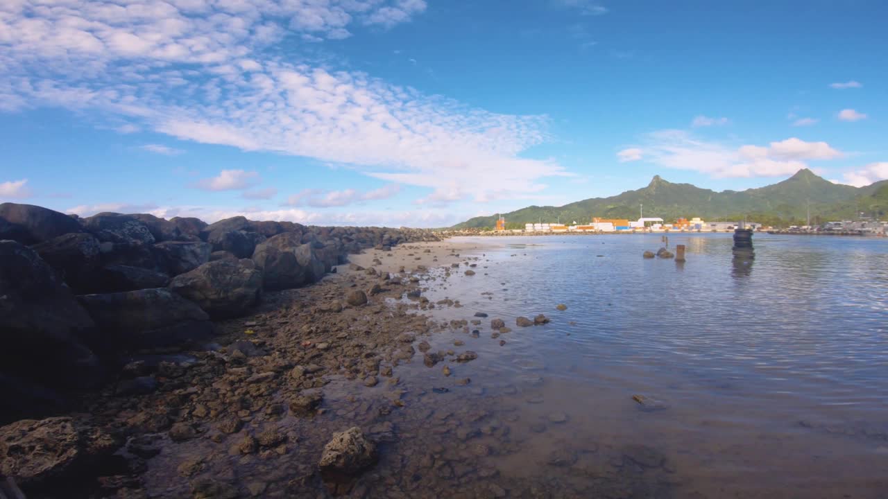 在阿瓦蒂乌港的沙岩海湾地区的水平窗格视图向外看船，运输船，建筑和侏罗纪公园像山脉远背景在良好的风化日蓝天视频素材