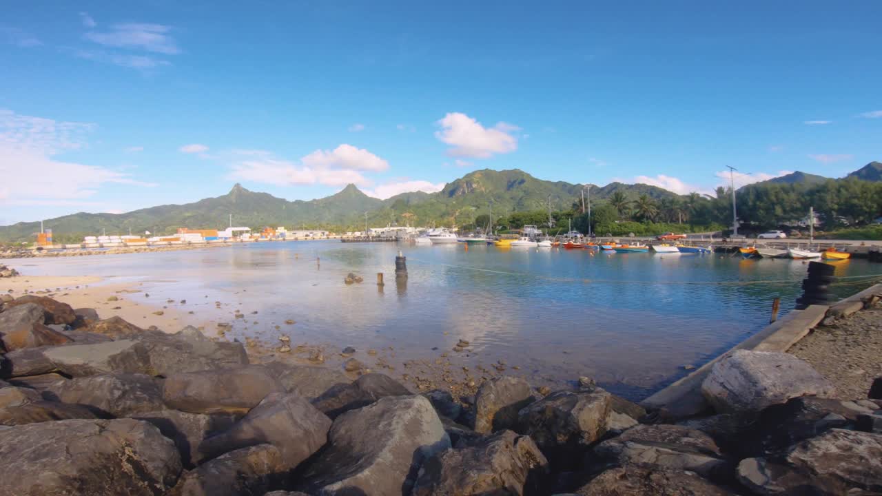 在阿瓦蒂乌港的沙质岩石海湾地区，眺望船只、运输船、建筑物和侏罗纪公园，远处的背景是饱经风雨的蓝天视频素材