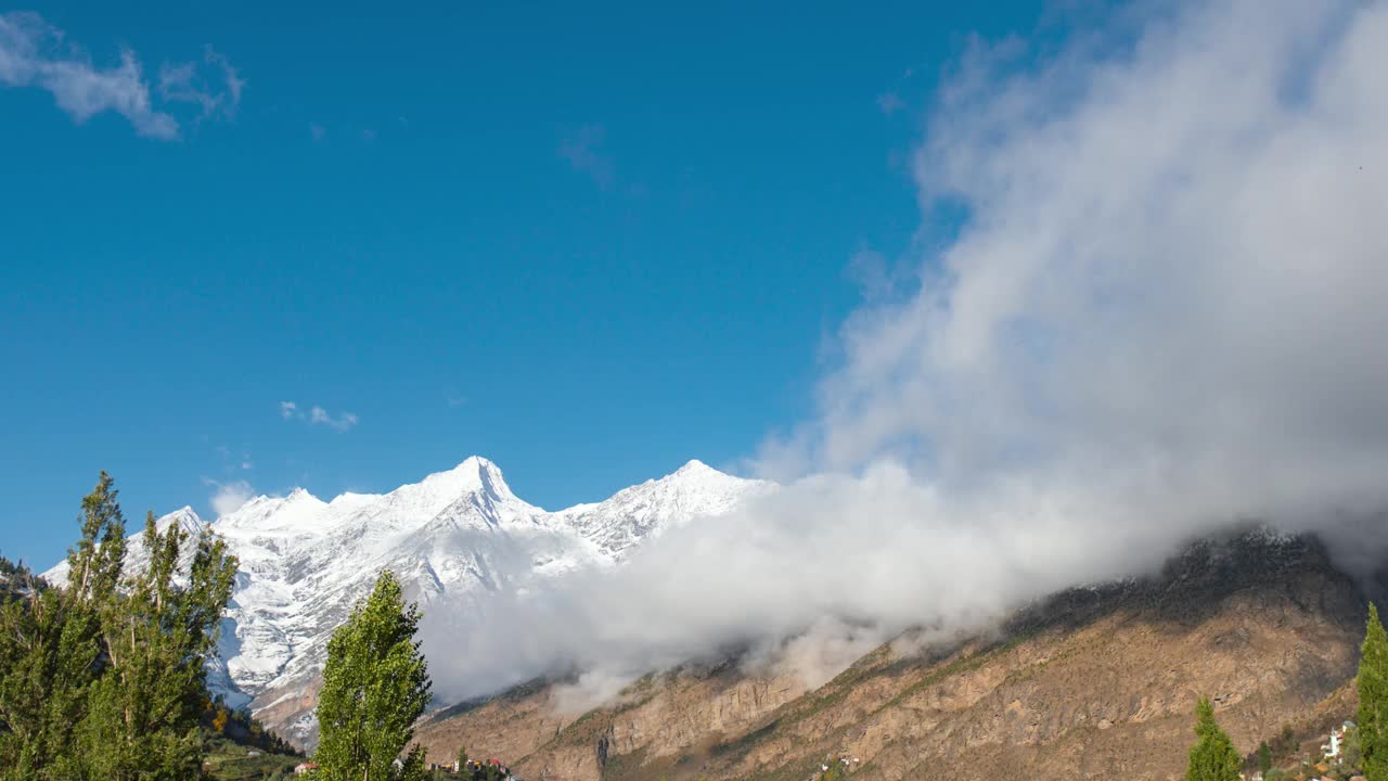 印度拉哈尔雪山下移动的云。喜马拉雅山顶的云层之上。云层覆盖山脉的时间。山谷中的低云。视频素材