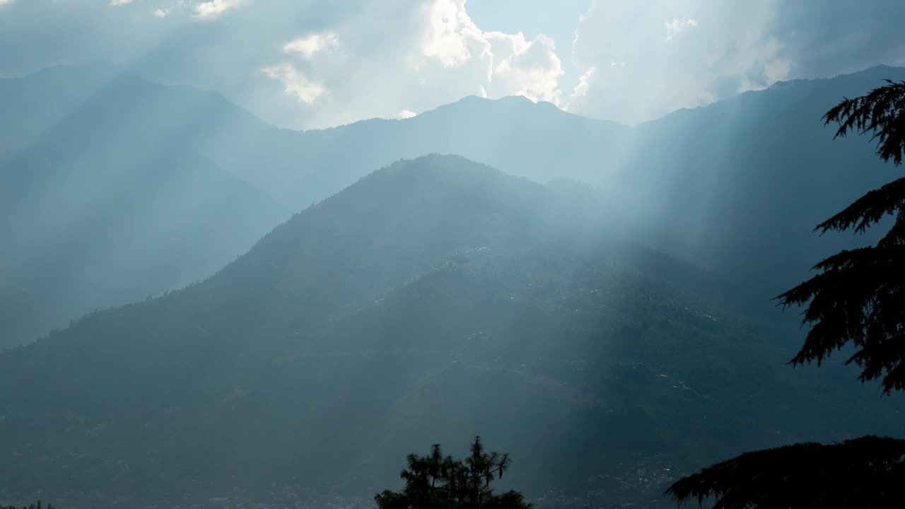 4K延时拍摄的迷人的太阳光线在印度纳格尔的山影上移动。群山和上帝的光芒会随时间流逝。梦幻般的阳光，美丽的天气。宁静的自然景观。视频素材