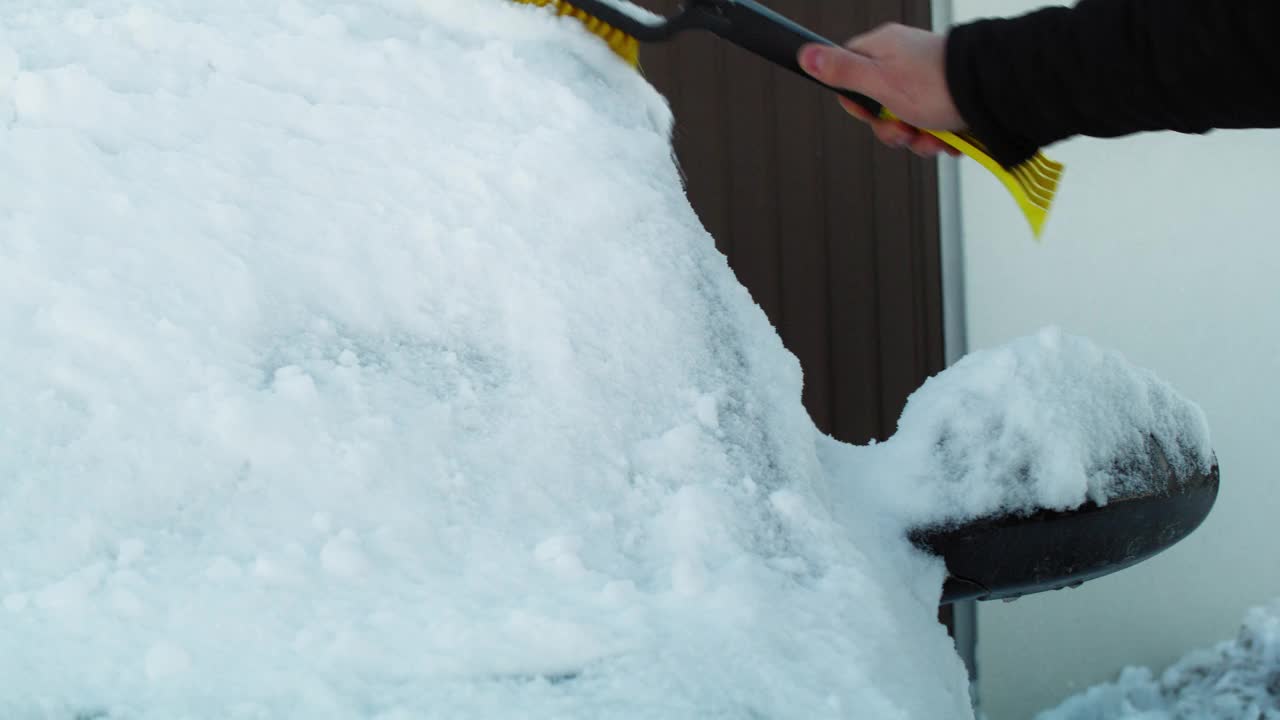 一名男子正在清除车窗上的积雪视频素材