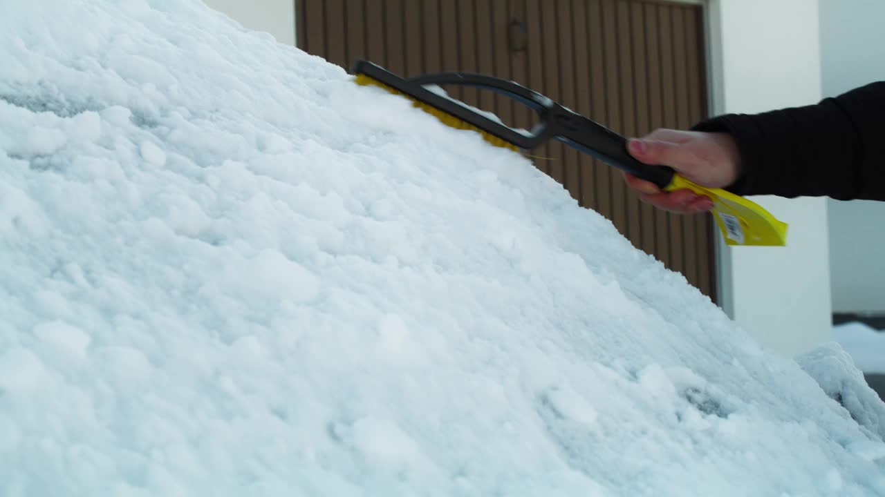 一名男子正在清除车窗上的积雪视频素材