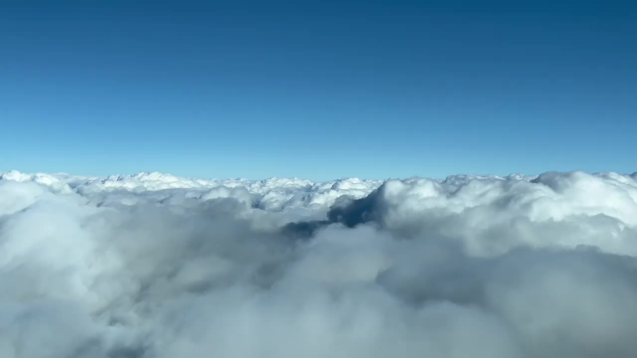 从飞机机舱拍摄的云景，在云层上飞行，天空晴朗而灿烂。飞行员的观点。10000米高。视频素材