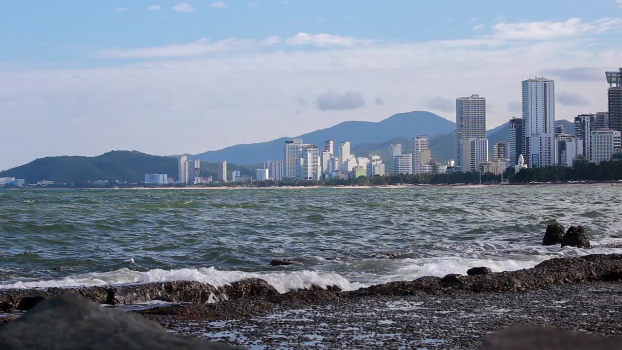 冲浪俯瞰城市，平静的海浪，海岸线上的钢筋混凝土防御工事。视频下载