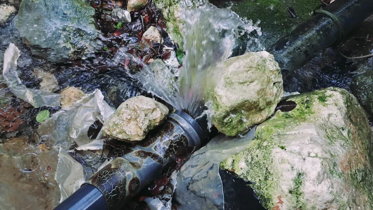 激烈的漏水场景:水从漏水的管道中喷出，突出了节约的必要性。特写展示了漏水的影响。石缝漏水，紧急环保重点视频素材