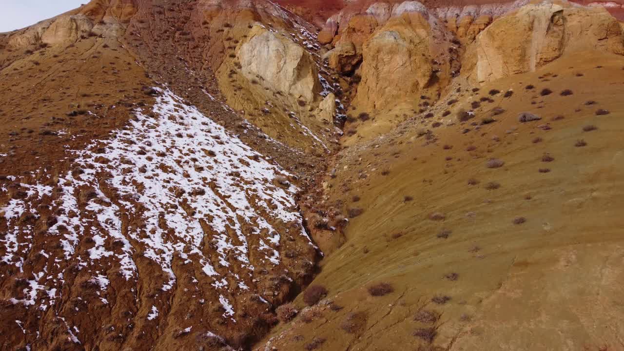 无人机拍摄的粗糙的岩石山坡，白天有雪和巨石视频素材