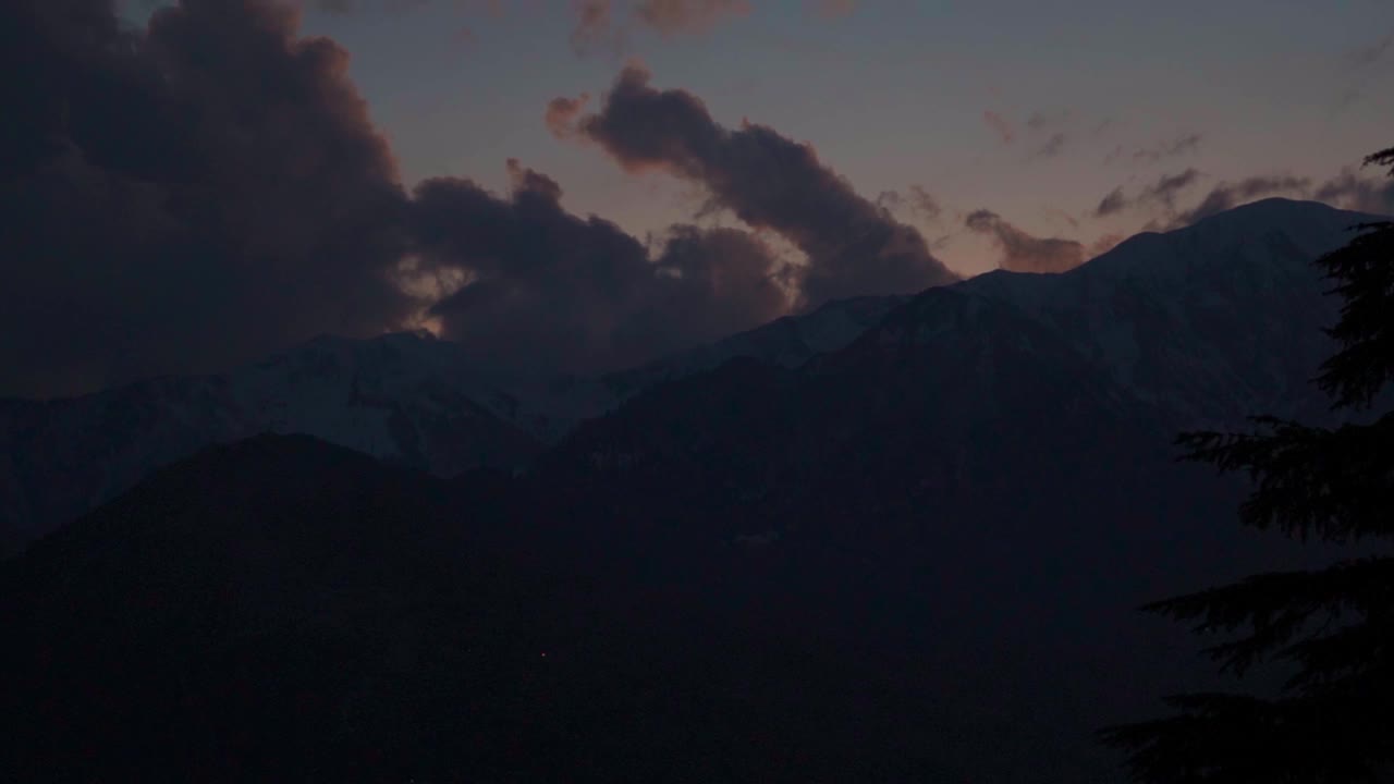 冬季，印度喜马偕尔邦马纳利的喜马拉雅山脉，积雪覆盖的山峰上的橙色云。冬天山上美丽的日落。视频素材