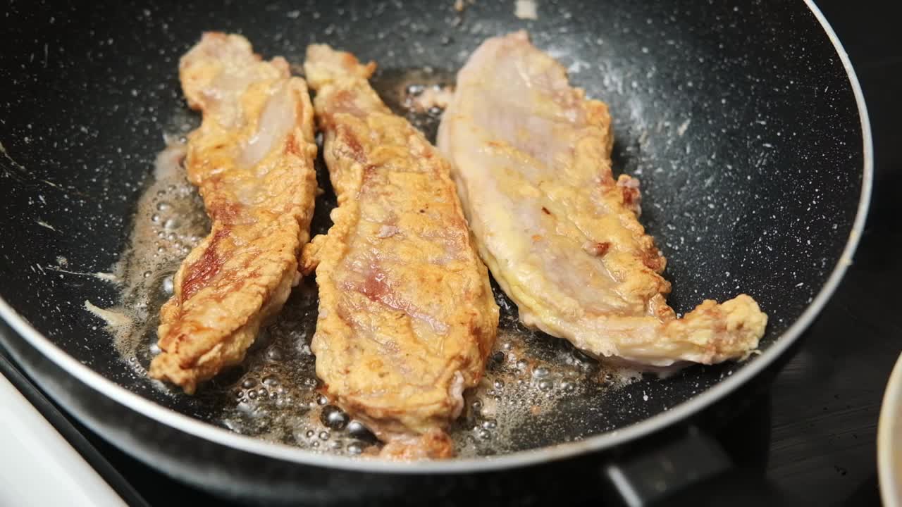 猪肉块，裹上面包屑，在平底锅里煎视频素材