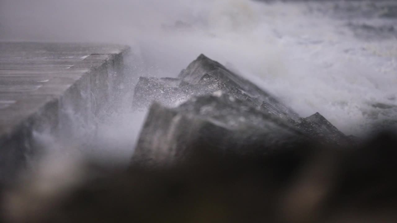 浅层聚焦在防波堤上，狂风吹起浪花和泡沫视频素材