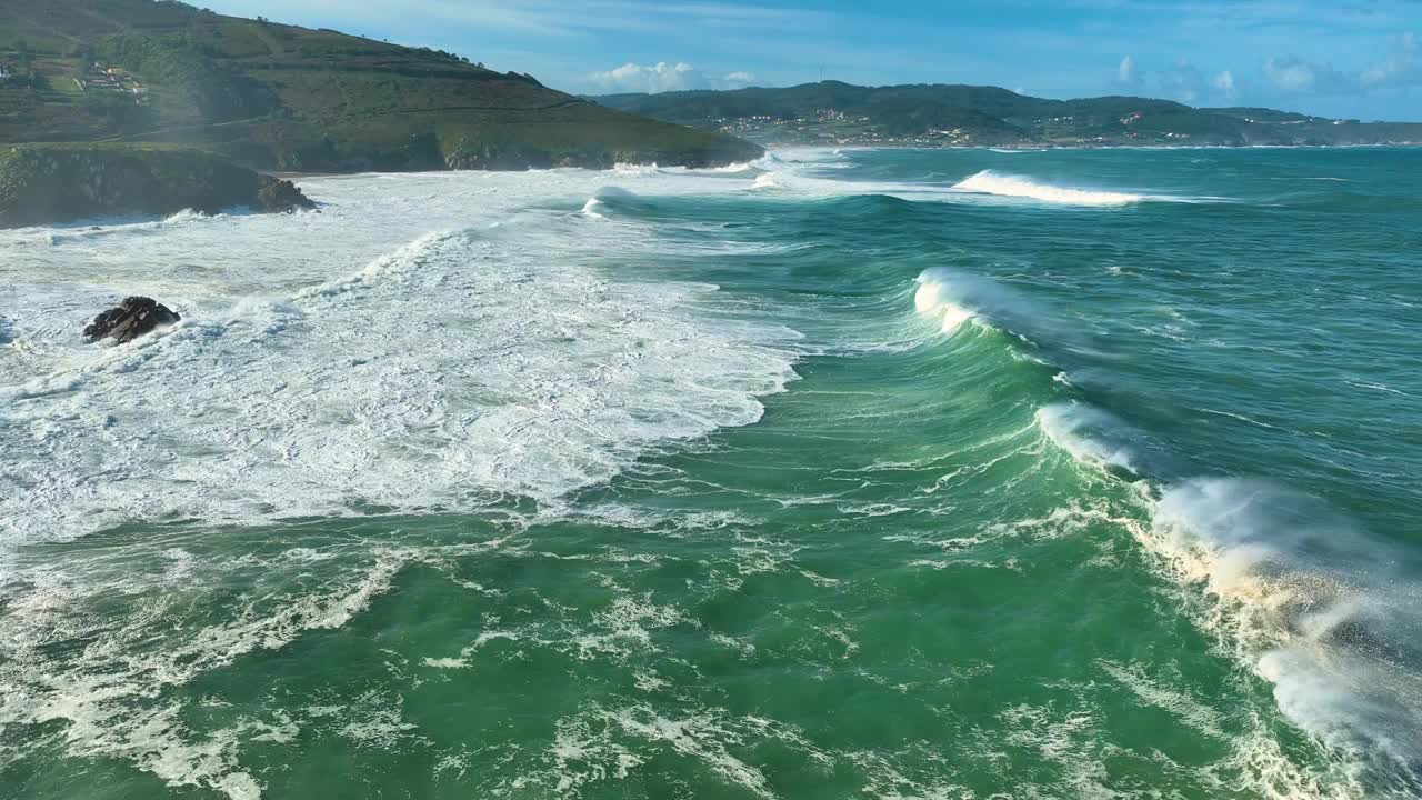 在西班牙科鲁尼亚的阿特伊索，泡沫汹涌的海浪拍打着瓦尔科博海滩的岩石海岸。无人机航拍视频素材