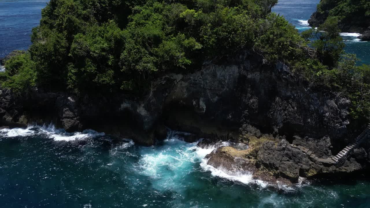 印度尼西亚努沙佩尼达岛海岸外一个被蓝色海水包围的小岛。天线。视频素材