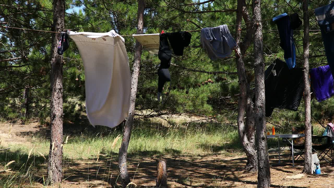 野外夏日森林的艳阳天:露营时晒衣服视频下载