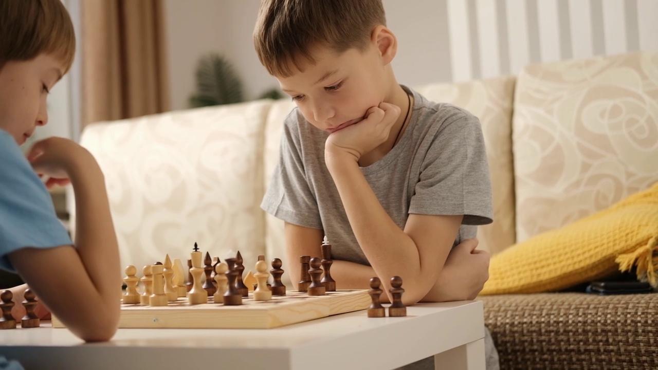 兄弟俩在家里下棋。孩子们在玩聪明的游戏。视频下载