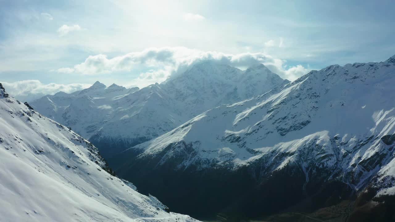 白天多云的天空下，白雪覆盖着高山视频素材