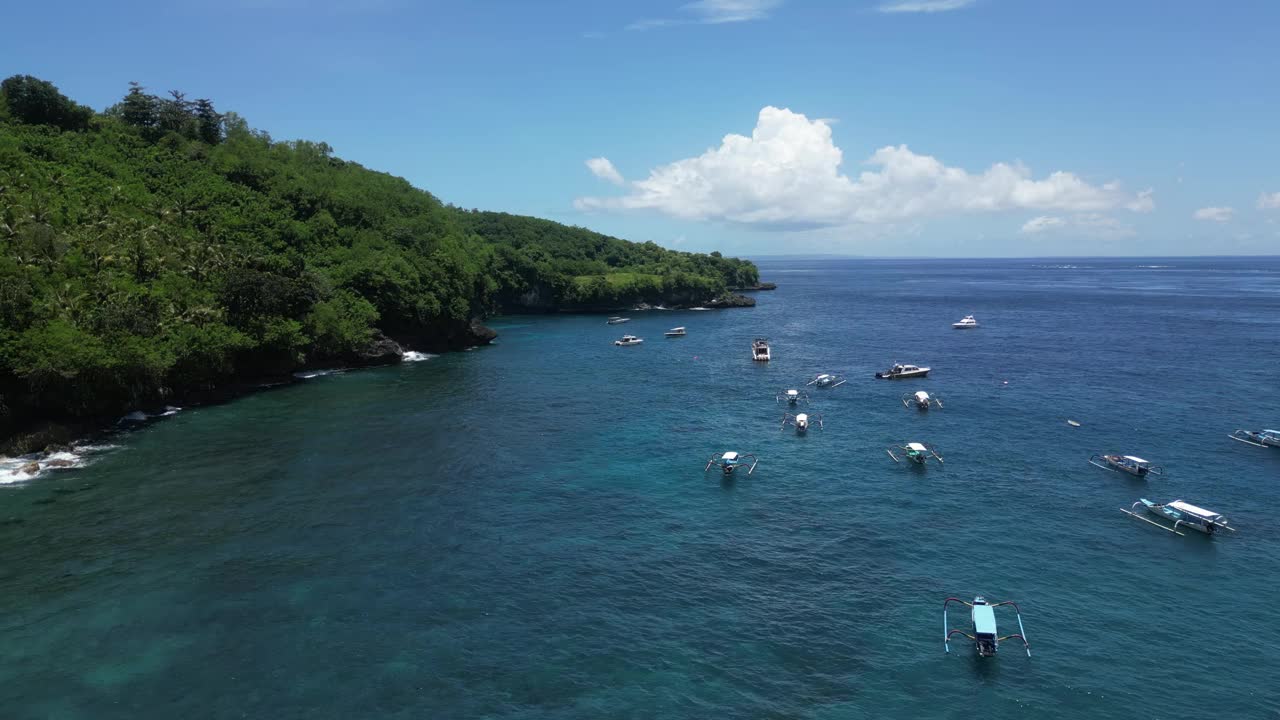 在阳光明媚的日子里，蓝色的大海上有许多船只，陆地上有森林风景。天线。视频素材