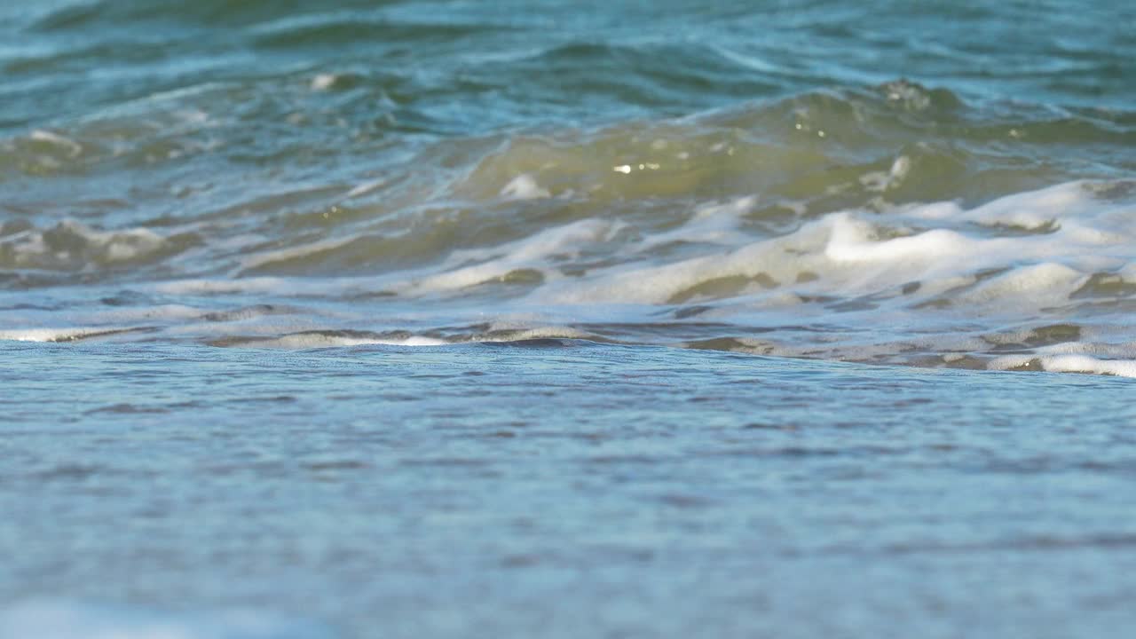 猛烈的海浪拍打着白色泡沫的特写镜头。视频素材