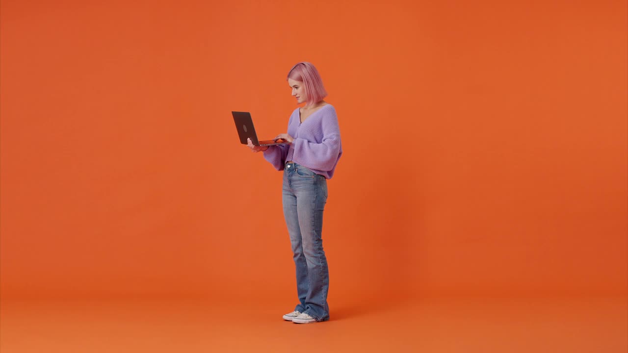 女人做了一个“是”的手势，看着展示的笔记本电脑视频素材