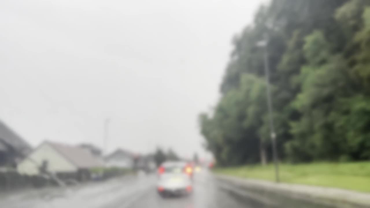 在大雨或雷雨天气开车在城市里转悠。天空中的闪电视频素材