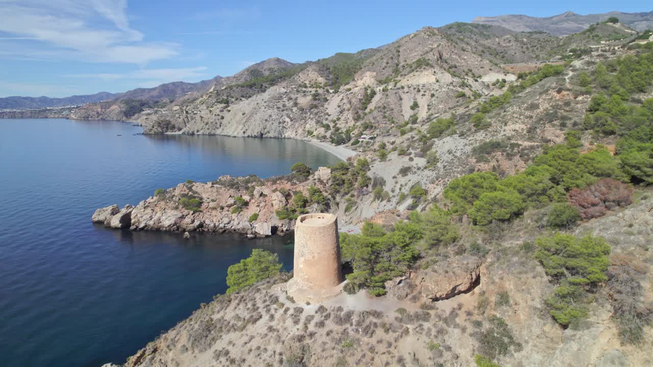 地中海沿岸悬崖边的中世纪瞭望塔。中世纪遗迹的轨道鸟瞰图，旁边是令人惊叹的蓝色大海和悬崖。安达卢西亚。西班牙。视频素材