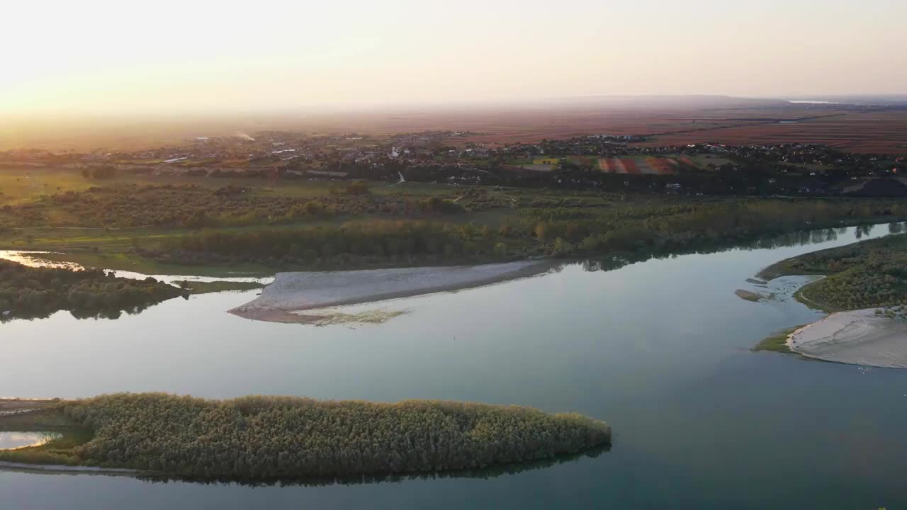 夕阳中，一架无人机飞过多瑙河，飞向塞尔维亚的Belegis村视频素材