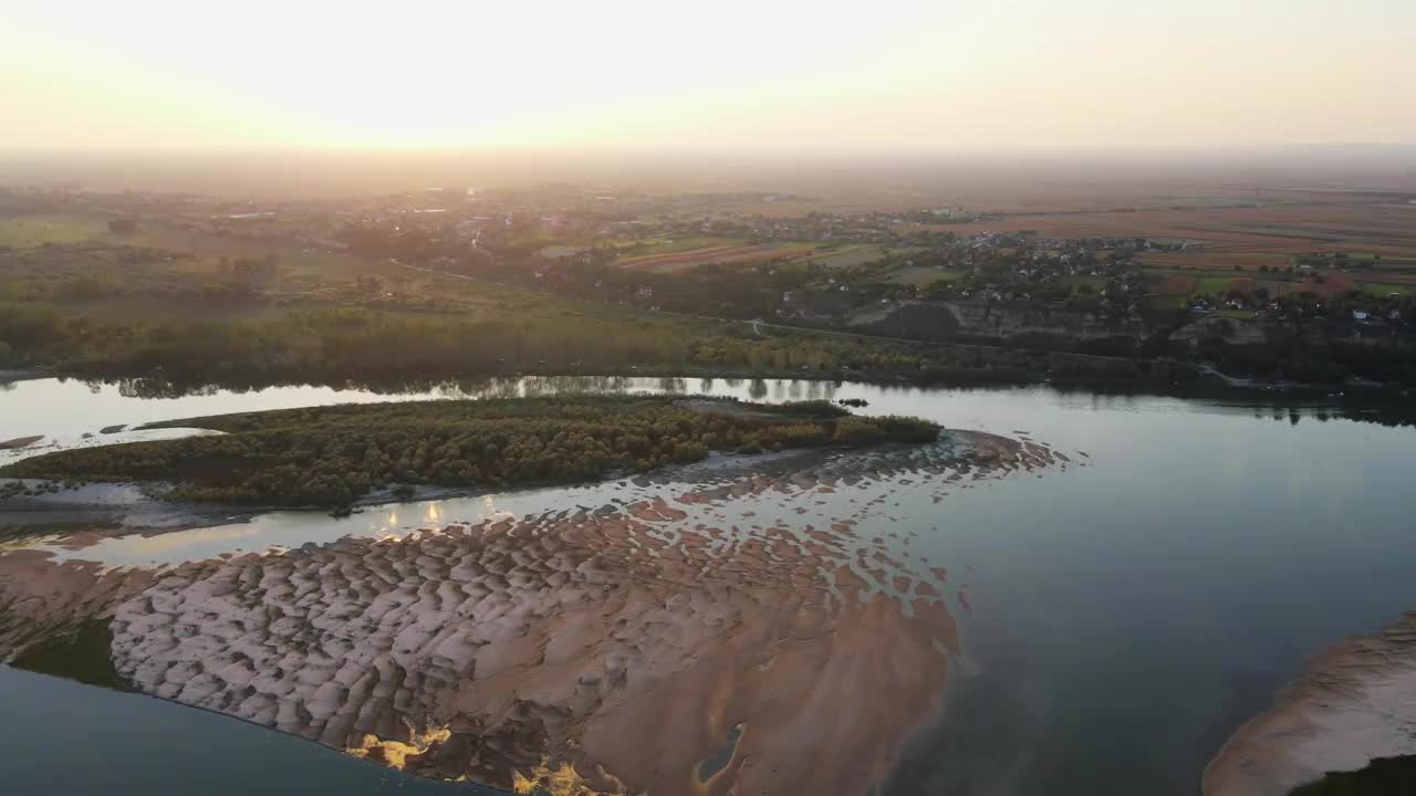 多瑙河岸边的一个村庄和周围的土地上的夕阳视频素材