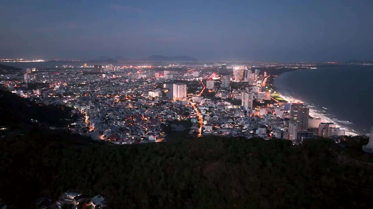 从上面俯瞰云头海岸全景，海浪、海岸线、街道、椰子树、越南Nho山后面的基督国王雕像视频下载