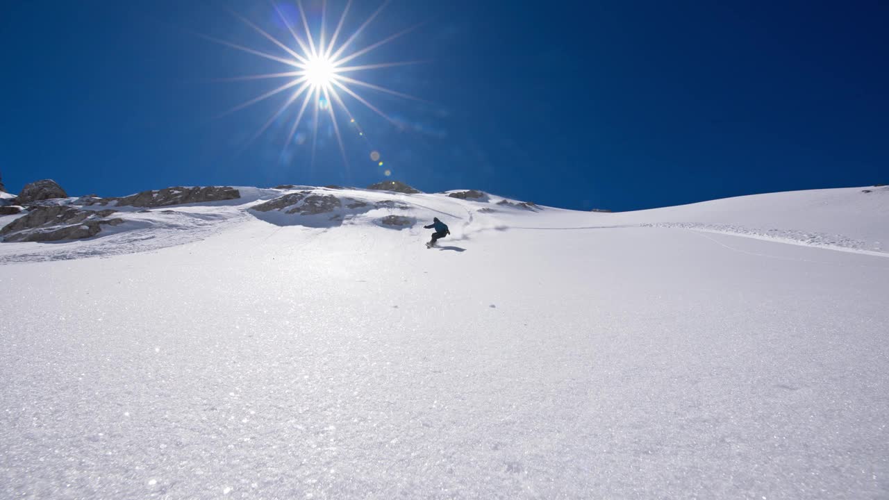 慢动作滑雪板选手在阳光下溅起粉末视频素材