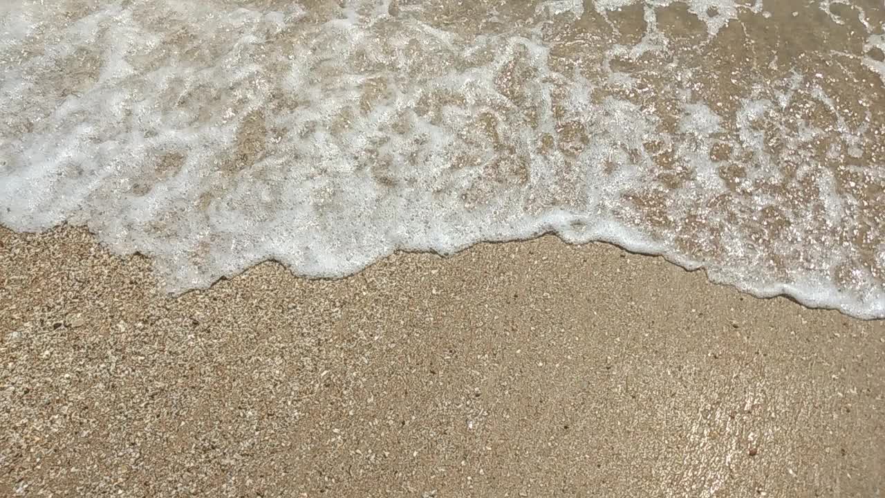 海浪卷起沙滩的特写镜头。海滩度假的概念视频下载