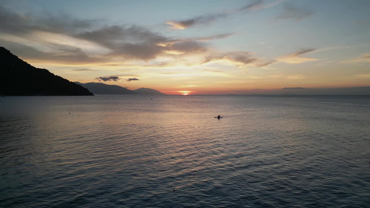 傍晚日落时分，游客在热带地区的海洋中游泳视频素材