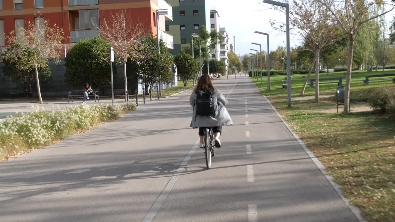 一个漂亮的女孩在公园里骑自行车视频下载