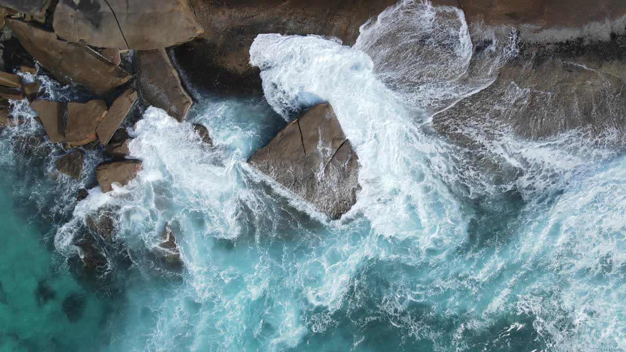 海浪有规律地冲击着岩石海滩视频素材