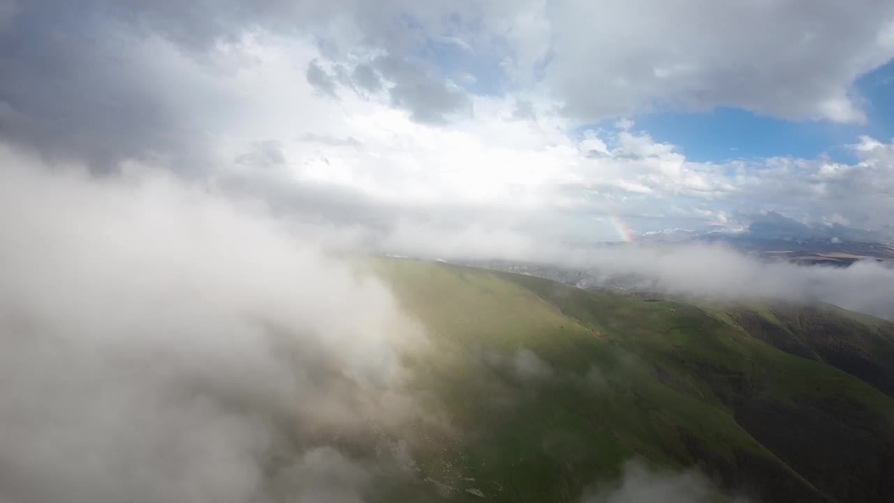 山间彩虹鸟瞰图，雨中彩虹飞翔图，山间彩虹鸟瞰图，山间彩虹鸟瞰图，雨后戏剧性的山云视频素材