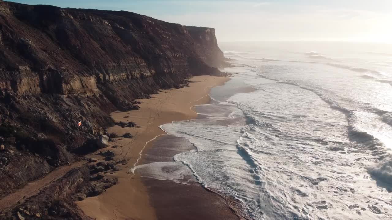 悬崖边的海滩波浪在葡萄牙，晨光-空中视频素材