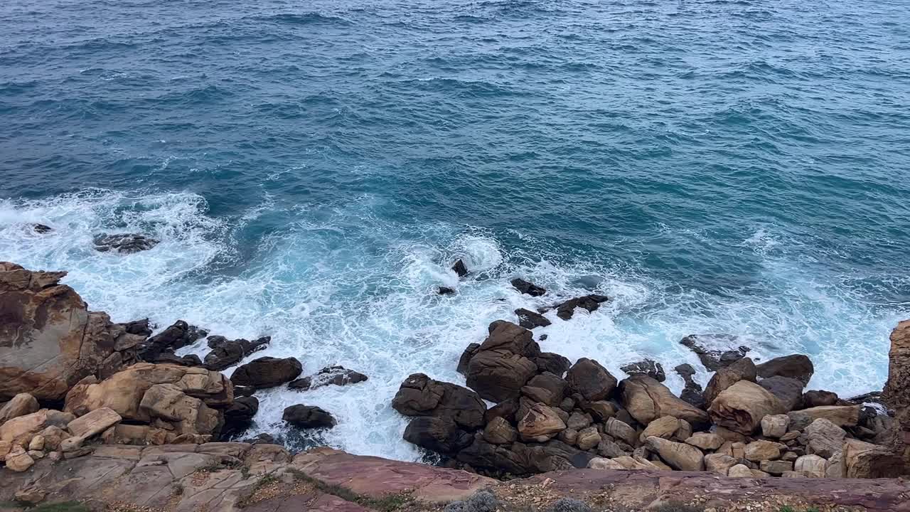 海浪在岩石海岸线上破碎的慢镜头。在这里，海洋的力量与岩石海岸的多样性相遇。原始自然概念。视频素材