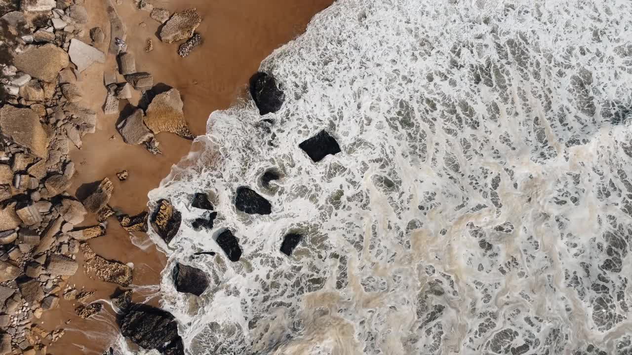 海浪冲击着葡萄牙纳扎雷的岩石海岸线，这里是海洋的力量与广阔的岩石海岸汇合的地方。以4K呈现。视频素材