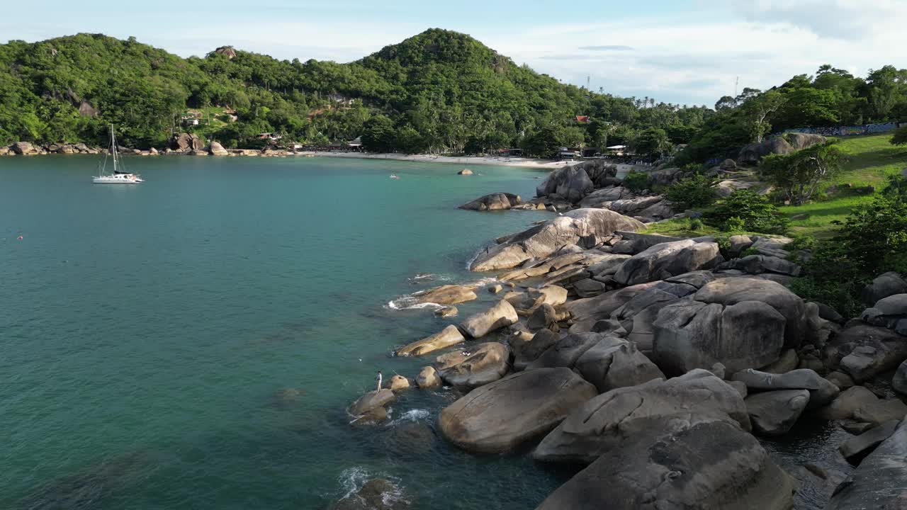 苏梅岛岩石海滩的静态照片，附近有静水、海岸和停靠的船只视频素材