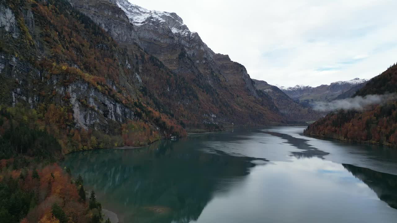 缓慢前进的潘镜头湖在山谷之间的山与雪覆盖的山峰视频素材