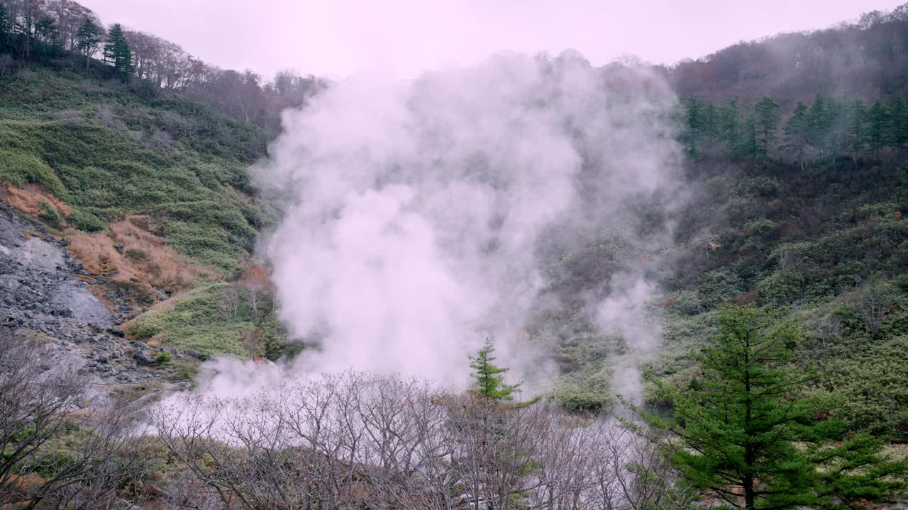 在日本东北部秋田市的玉川温泉附近，蒸汽从被森林群山环绕的地热池中缓缓飘出，营造出一种宁静的氛围。旅游目的地为观察温泉地区的自然力量。视频素材