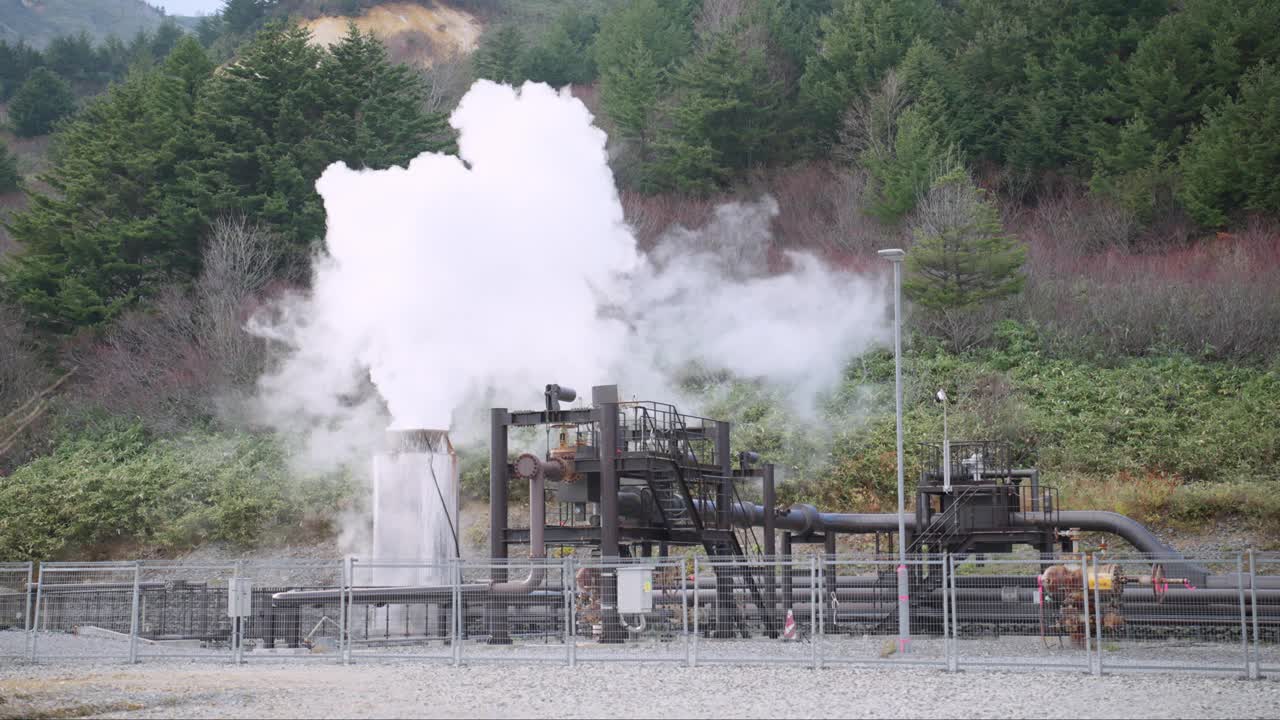 在日本东北秋田市的玉川温泉，厚重的白色蒸汽从塔和用于从温泉输送热蒸汽的管道中升起，这表明了自然地热活动与人类工程的和谐结合。视频素材